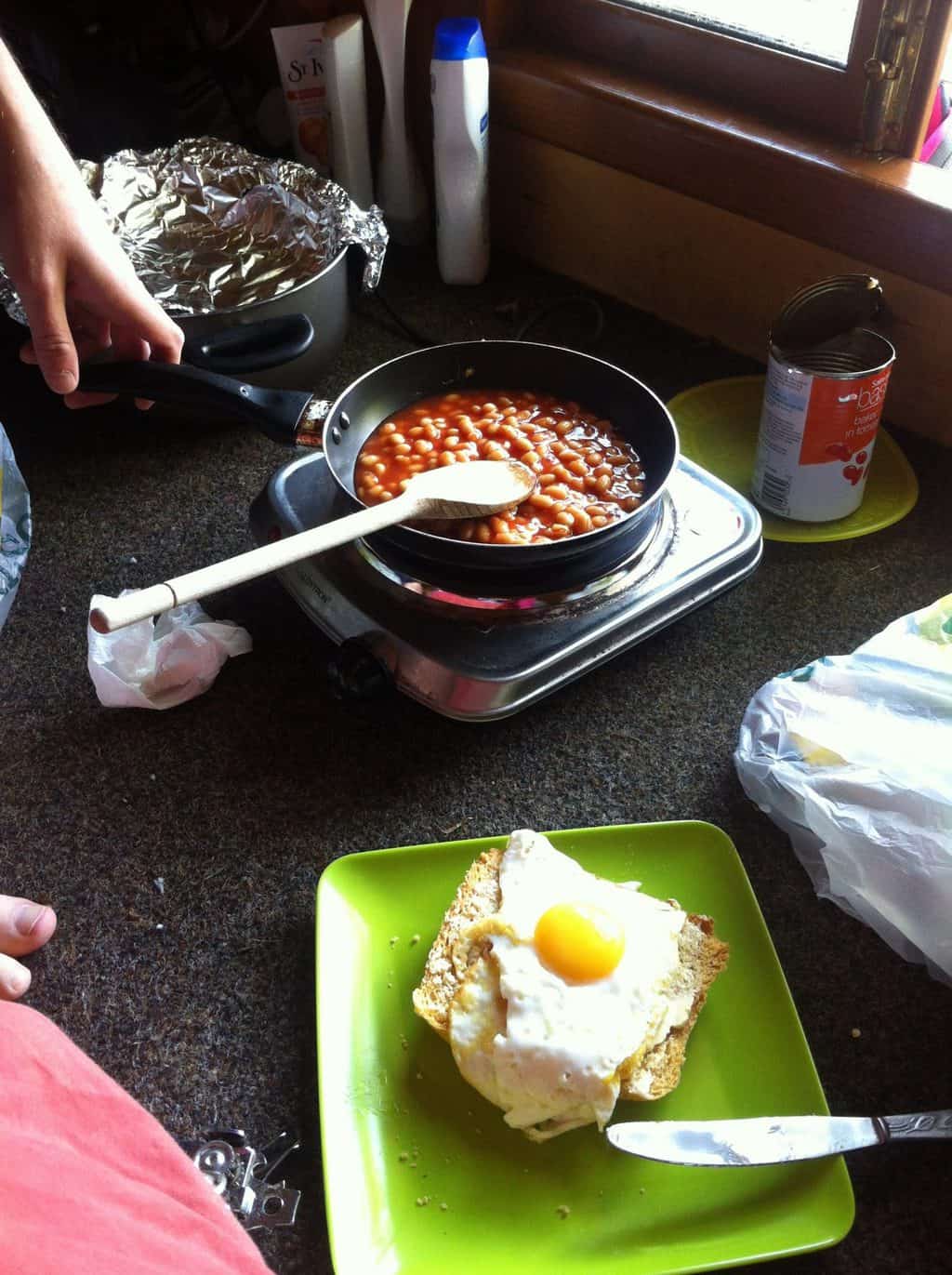 Cooking baked beans on an electric hob in a glamping hut