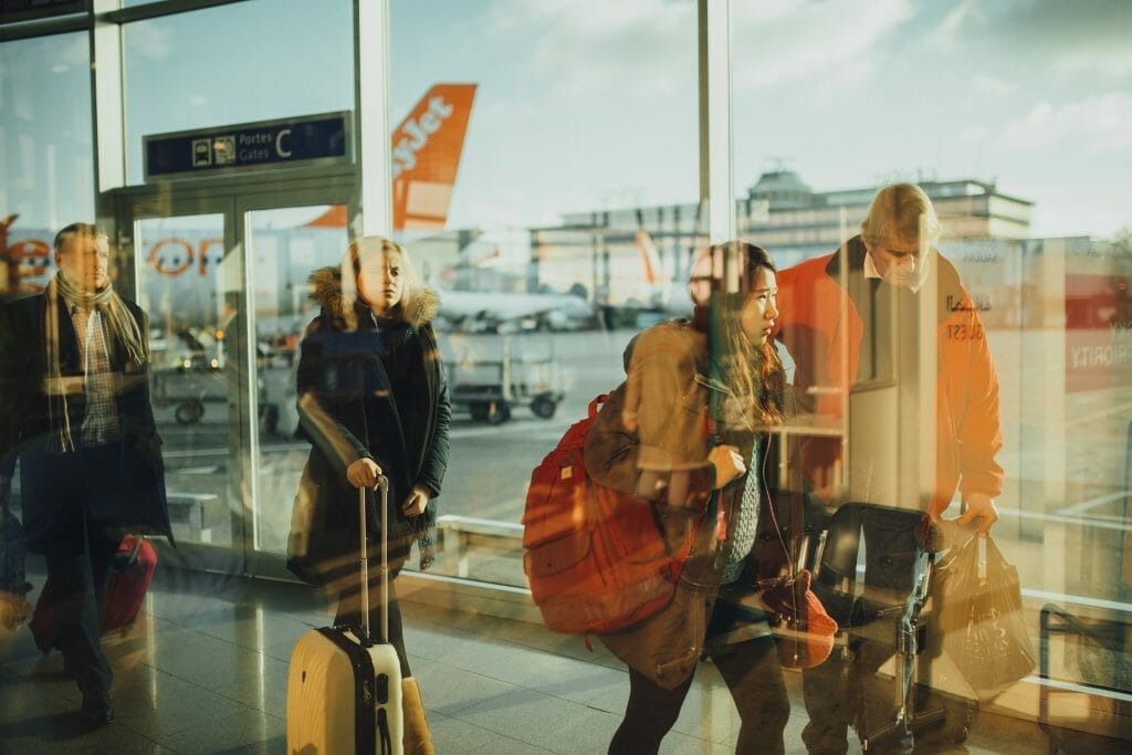 People walking through airport with planes in the background