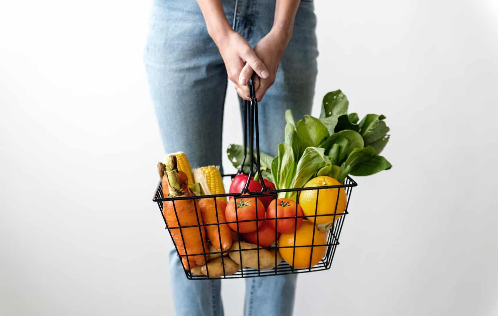 Woman holding shopping basket with food in it