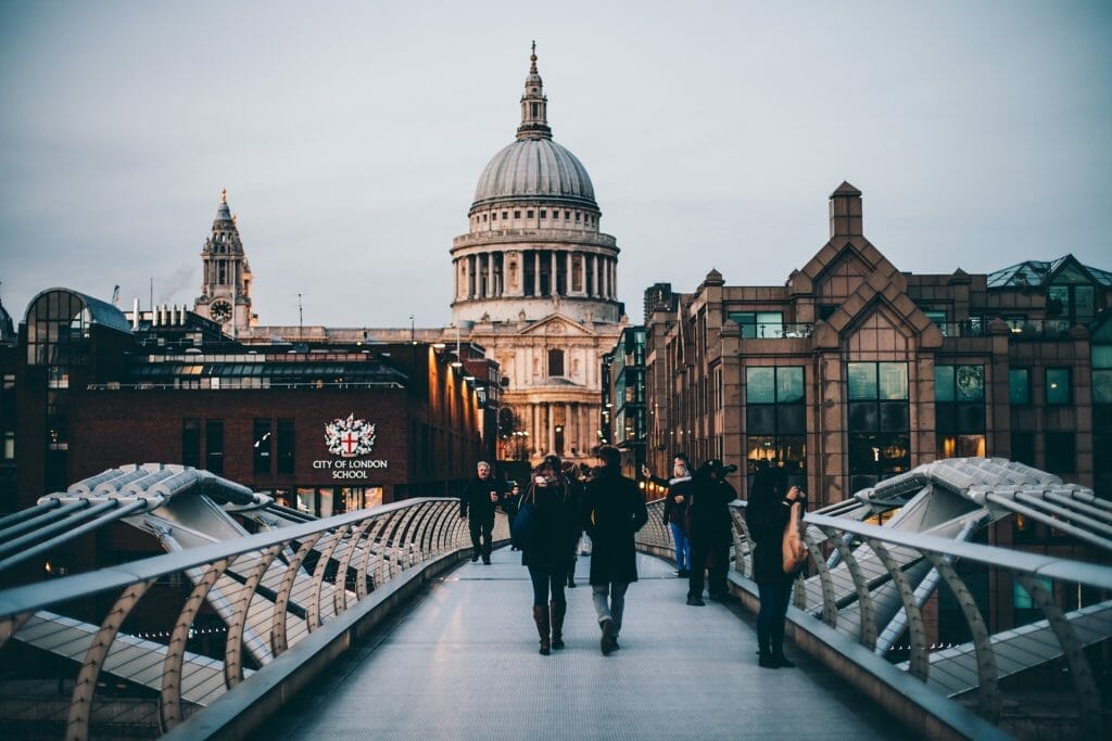 People walking on a bridge with St Paul's cathedral in the background
