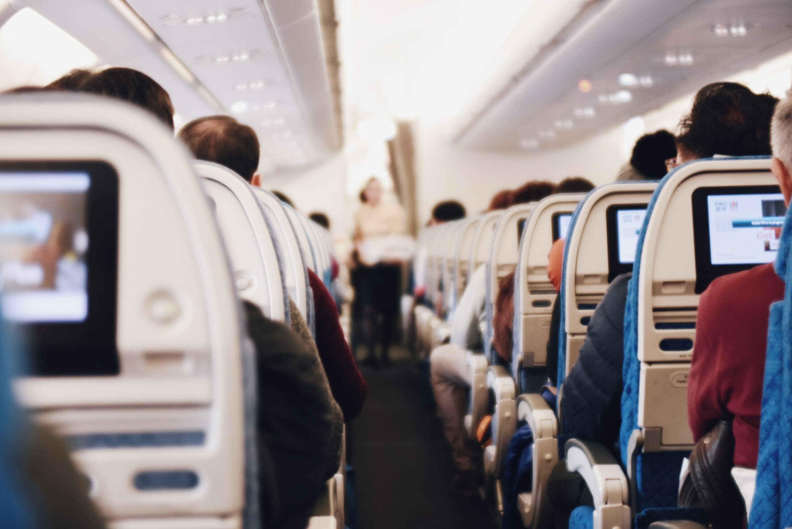 Looking down airplane aisle with people either side