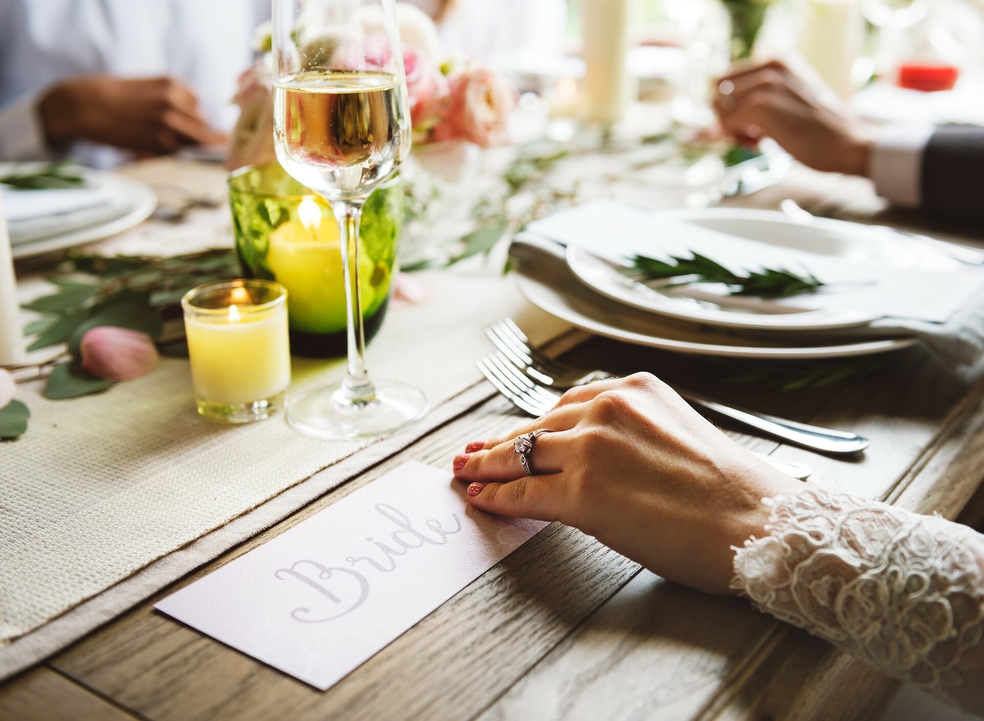 The hand of a Bridge sitting at a table ready to be served food