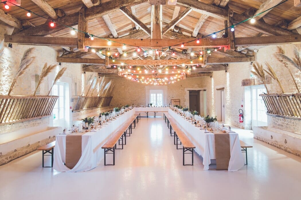 Wedding tables in a barn with benches
