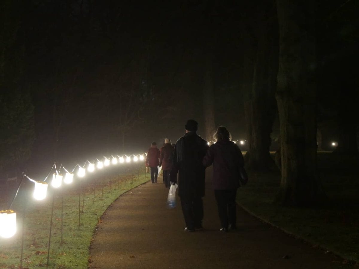 Night time lit path at Waddesdon Manor with people walking on it