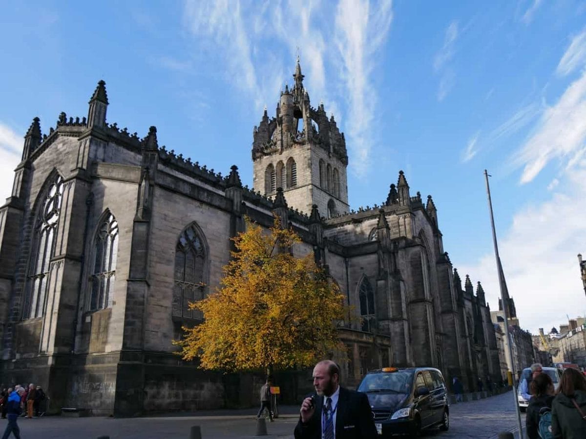 Edinburgh historic building with blue sky and autumn-leafed tree