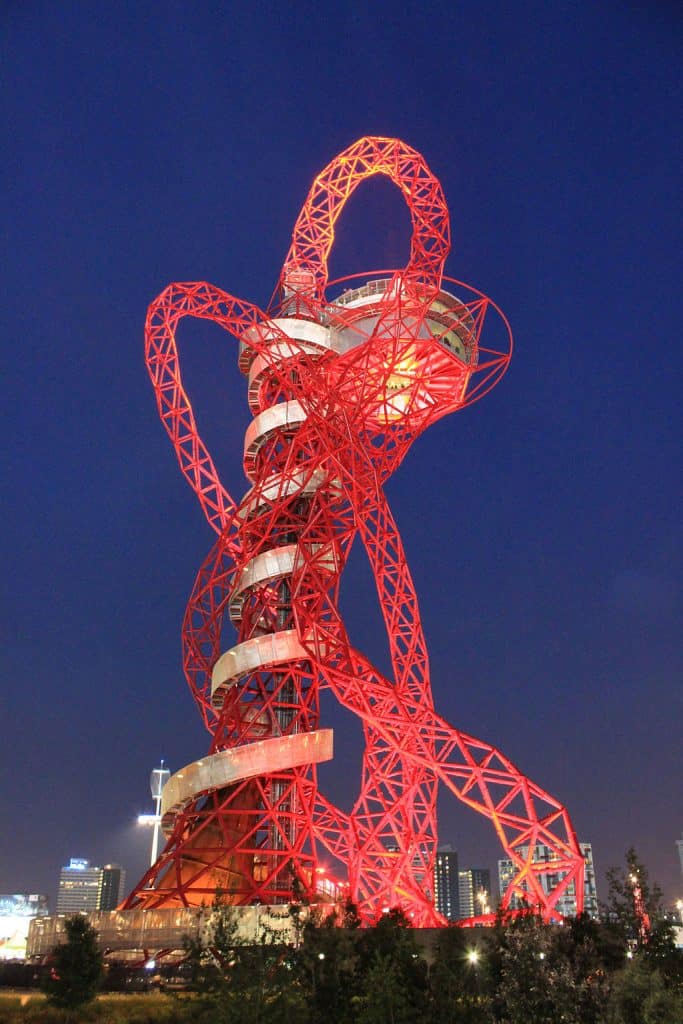Red steel frame curved tower in London Olympic Park with dark blue sky