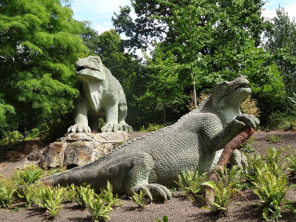 Two dinosaur statues surrounded by trees