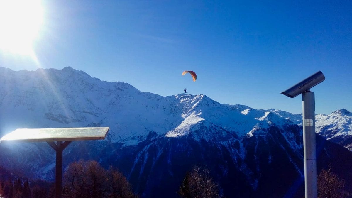 Parascender in Les Arcs with mountains and blue sky behind
