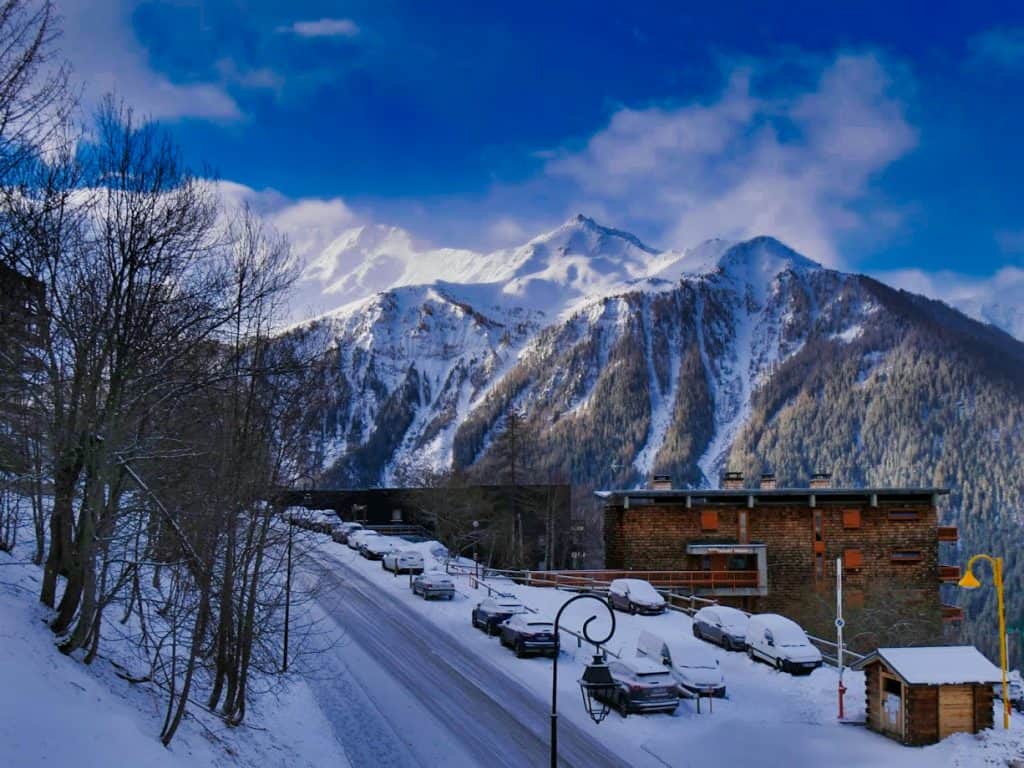 View from balcony in Peisey with deep blue sky and snowy mountain and snow-covered road