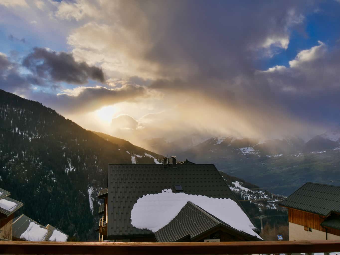 View over valley from apartment with sun shining through clouds