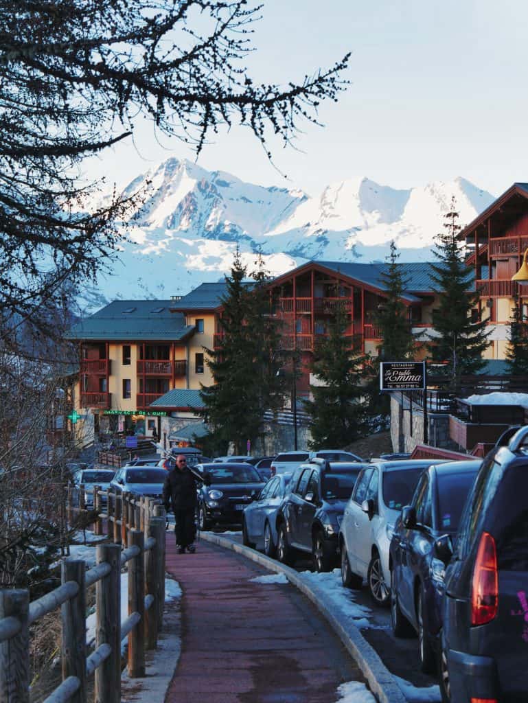 Shops in Peisey village in Les Arcs with person walking along pavement