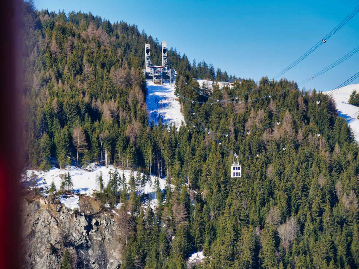 Vanoise Express cabin over valley in Paradiski with green trees in the background