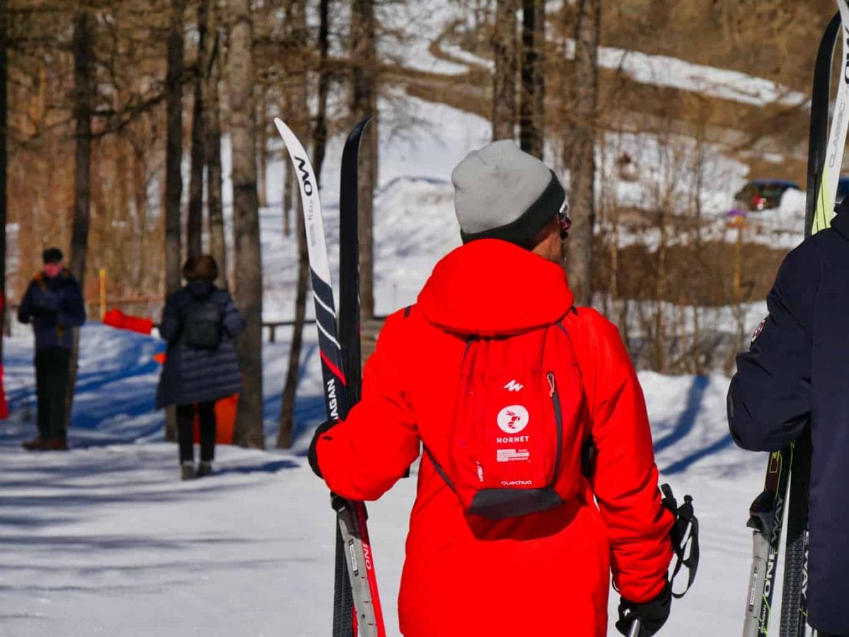 Person carrying Nordic skis in Nordic Ski area in Peisey-Nancroix