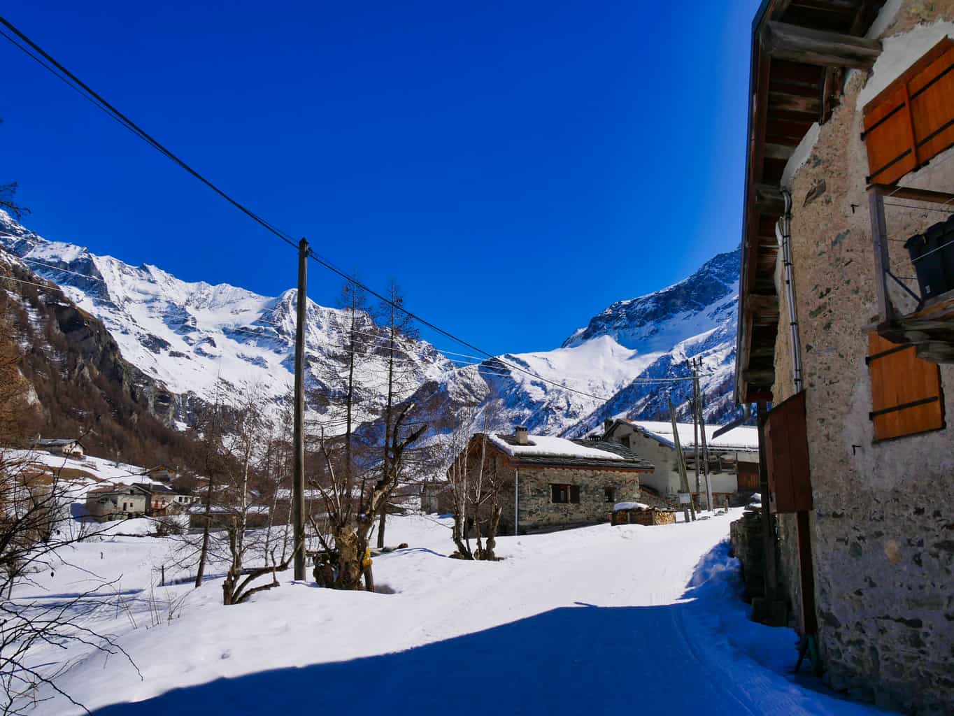 Rustic buildings in Nordic Ski Area in Paradiski with deep blue sky and snow