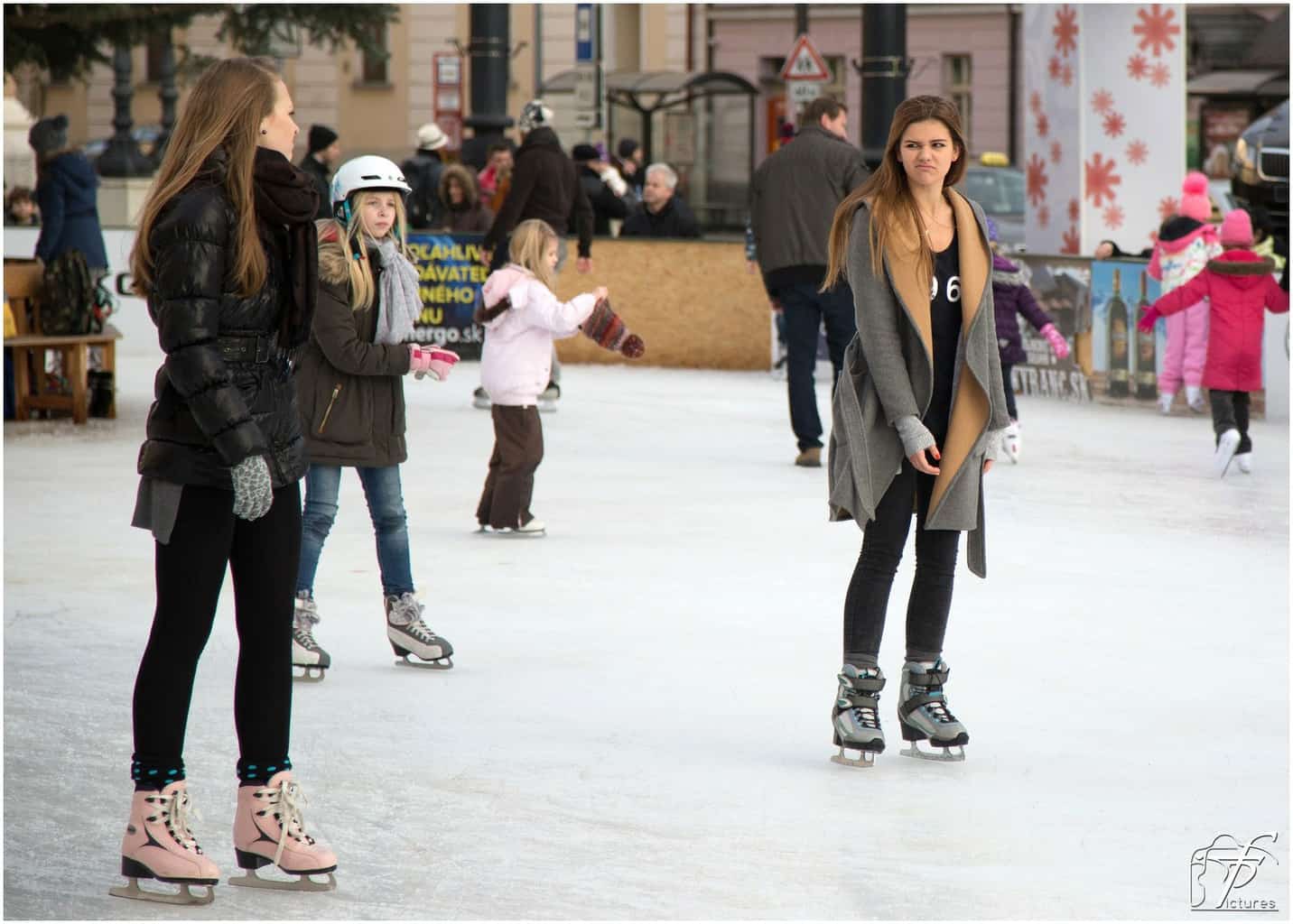 Two girls ice skating one with an upset face