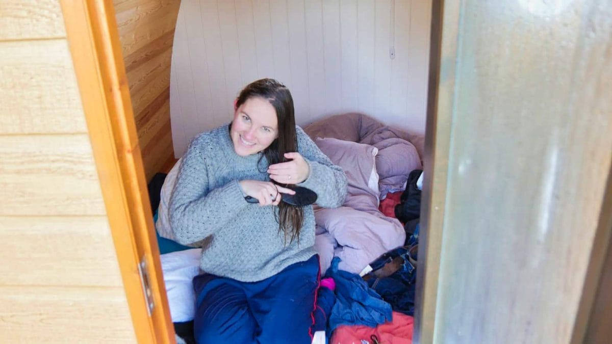 Kalyn brushing her hair in a glamping hut