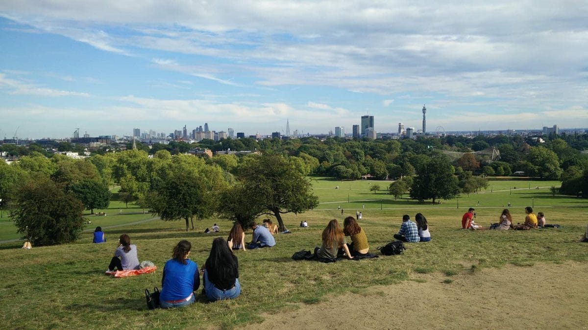 People sitting at Primrose Hill looking over London