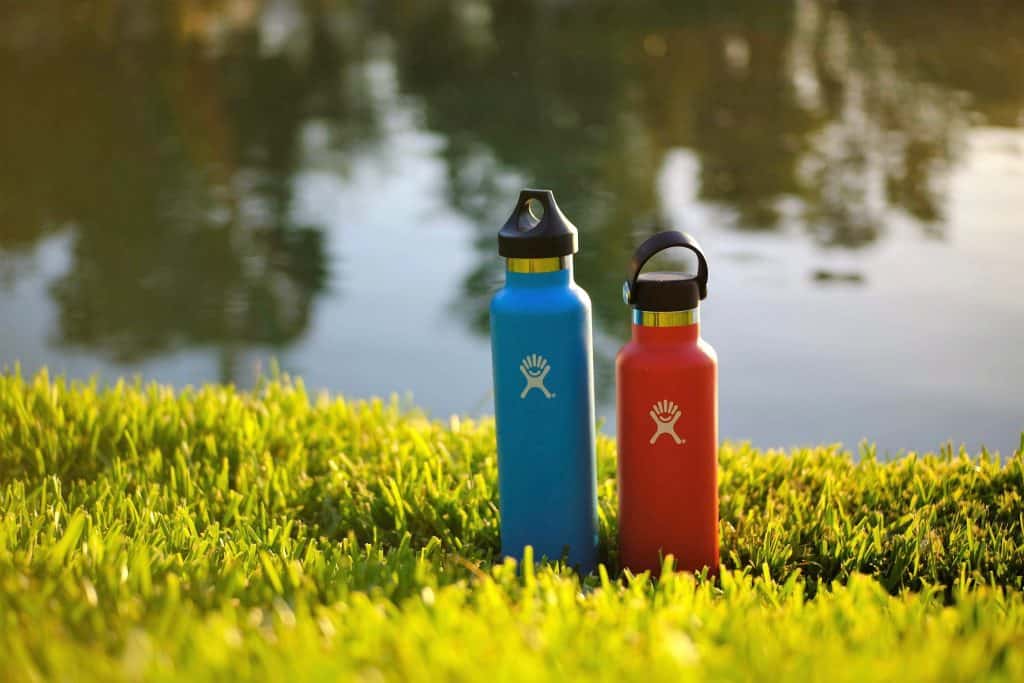 reusable water bottles next to lake