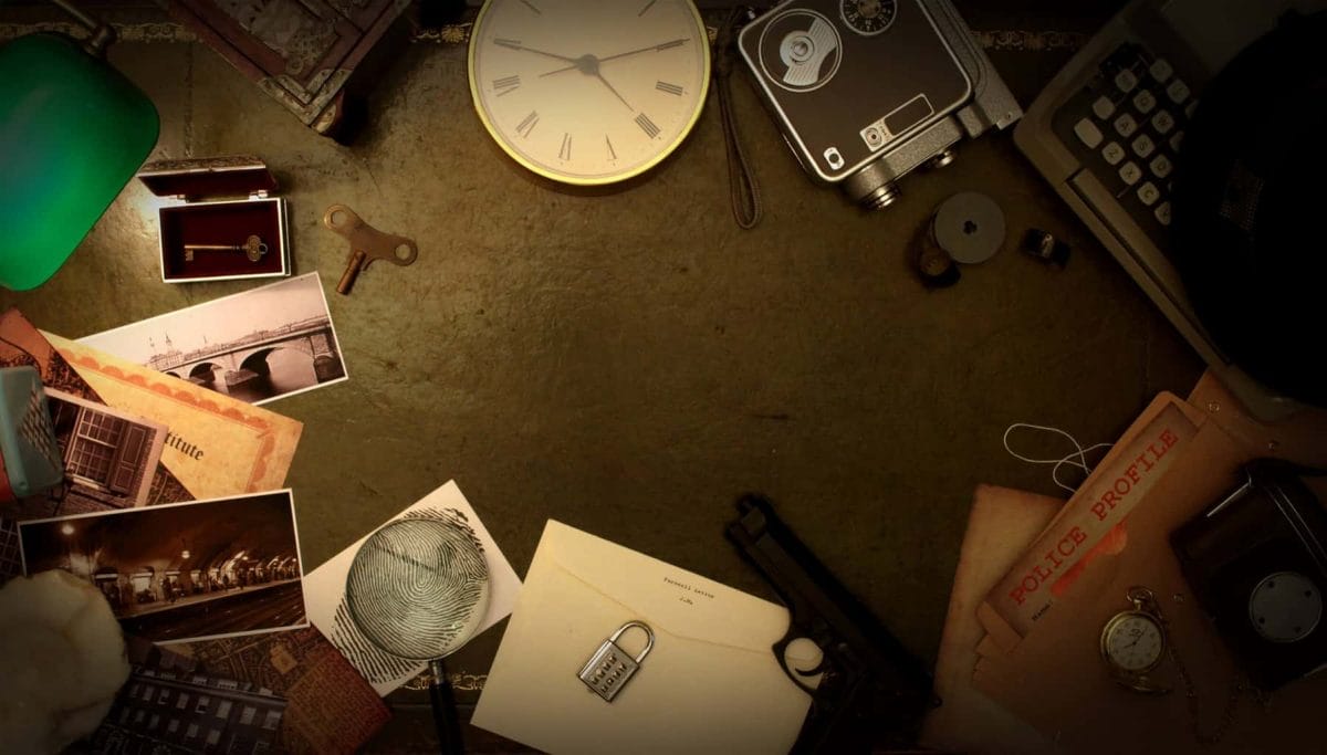 Escape room game props on a table, such as a clock, photographs, papers, and an audio recorder