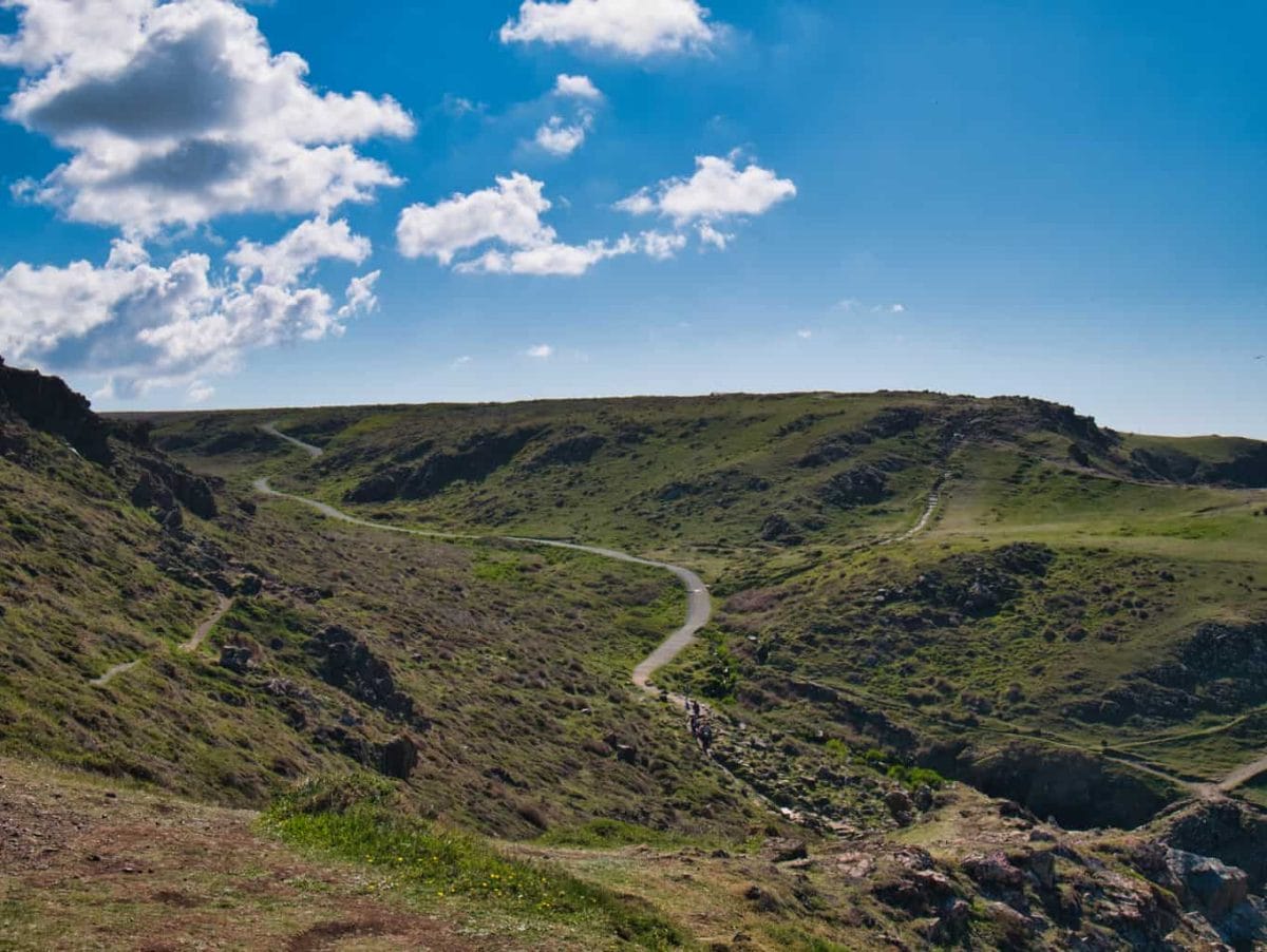 A path winding through the hills near Kynance Cove with people walking along it