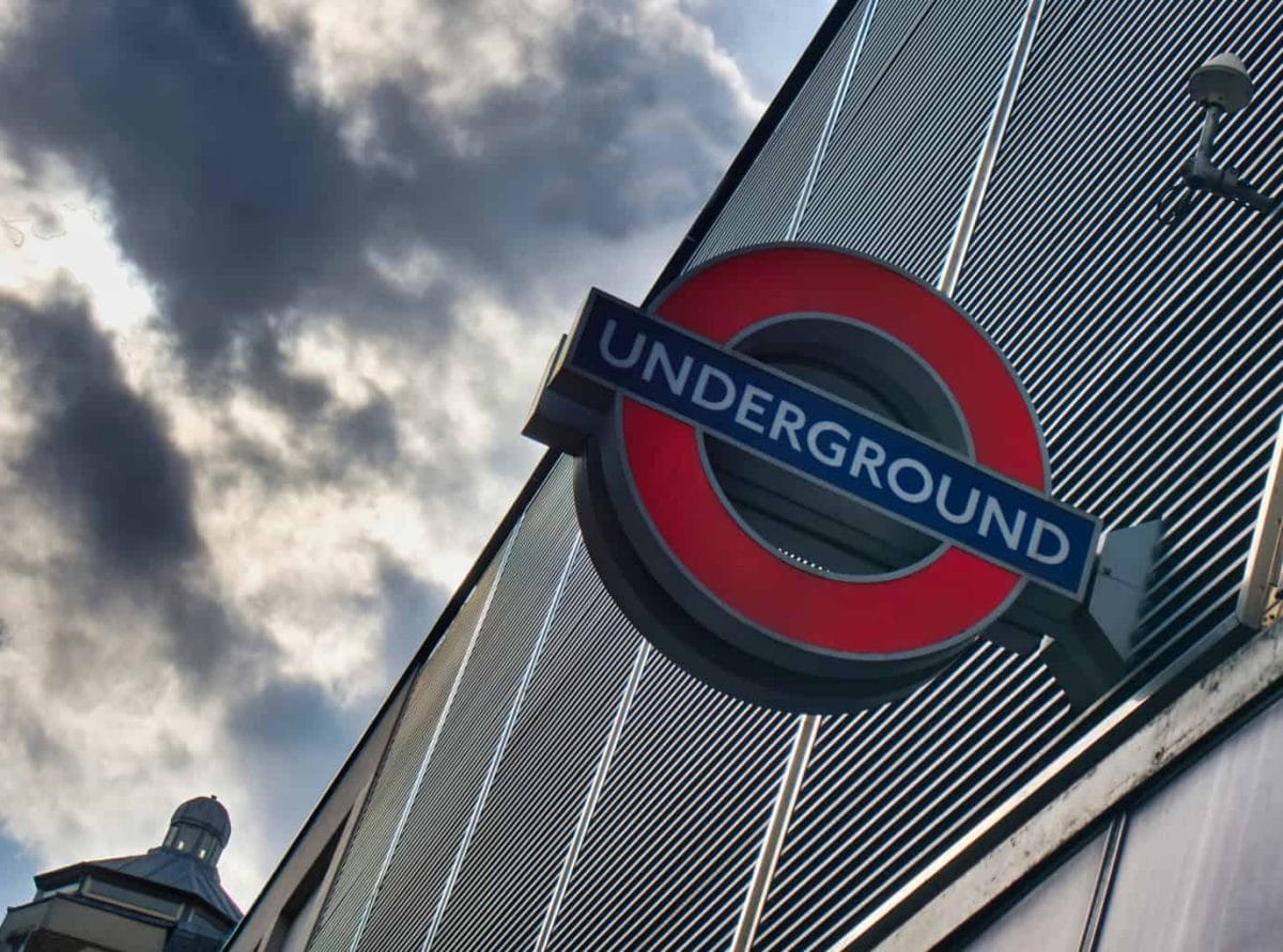 A close shot of a London Undergound sign with ominous clouds behind