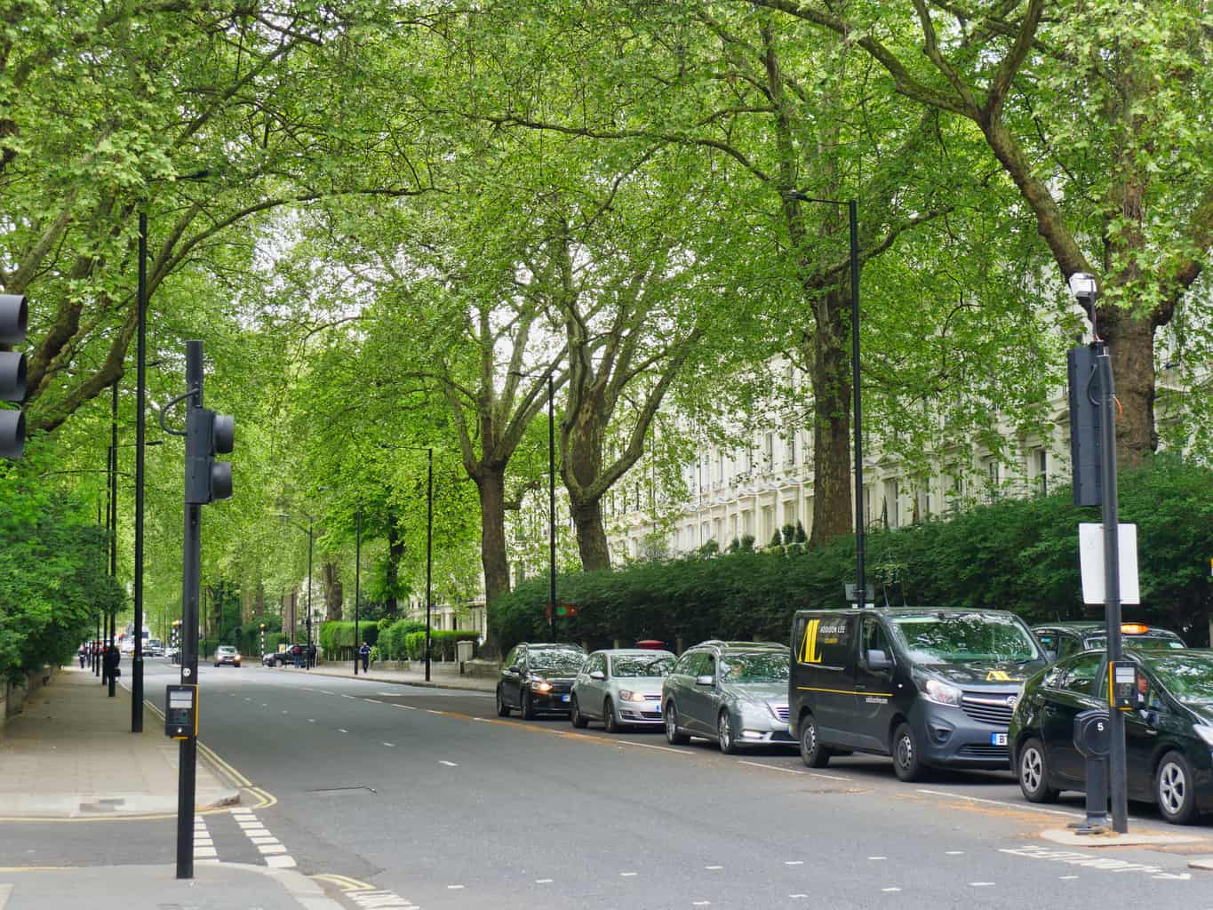 A street in London with cars and a van waiting at a traffic light