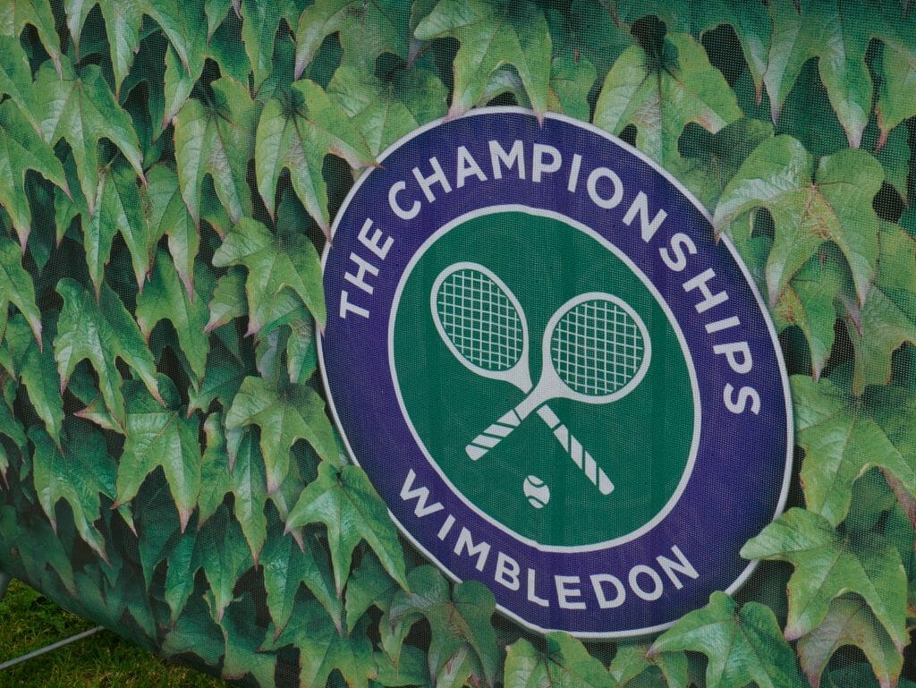 The Wimbledon logo surrounded by leaves printed on an advertising board