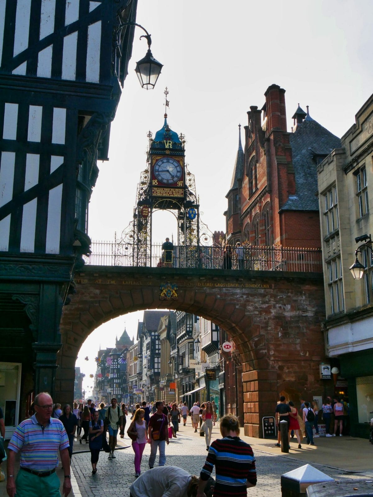 Chester High Street with an old, ornate clock on top of a bridge