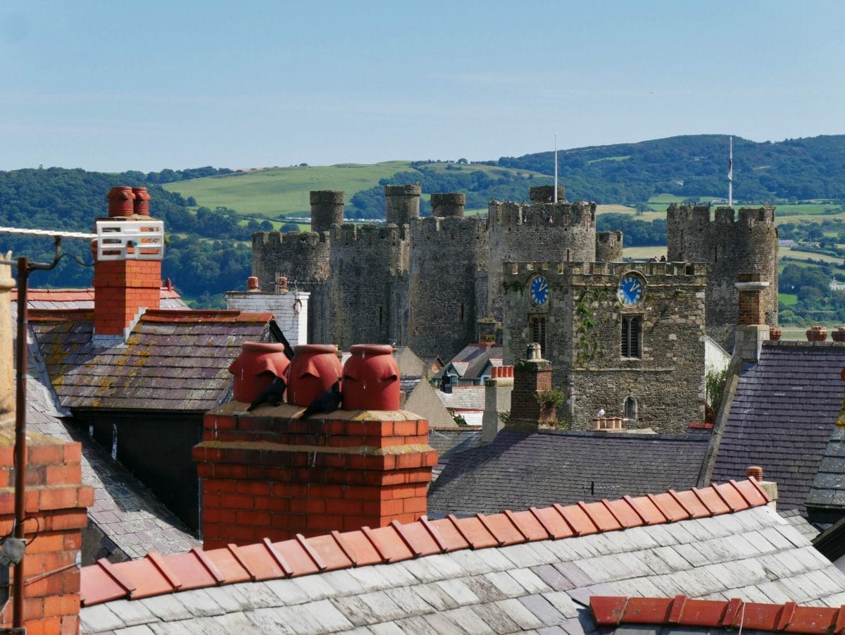 The rooftops of Conwy in Wales with a castle in the background
