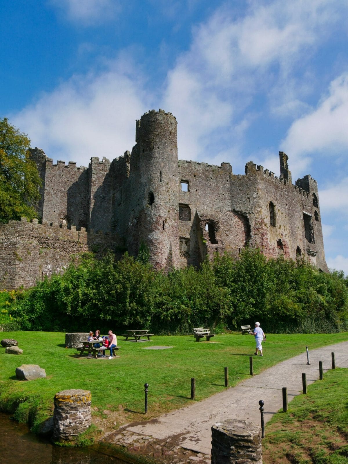 Laugharne castle Wales with people in front on the grass