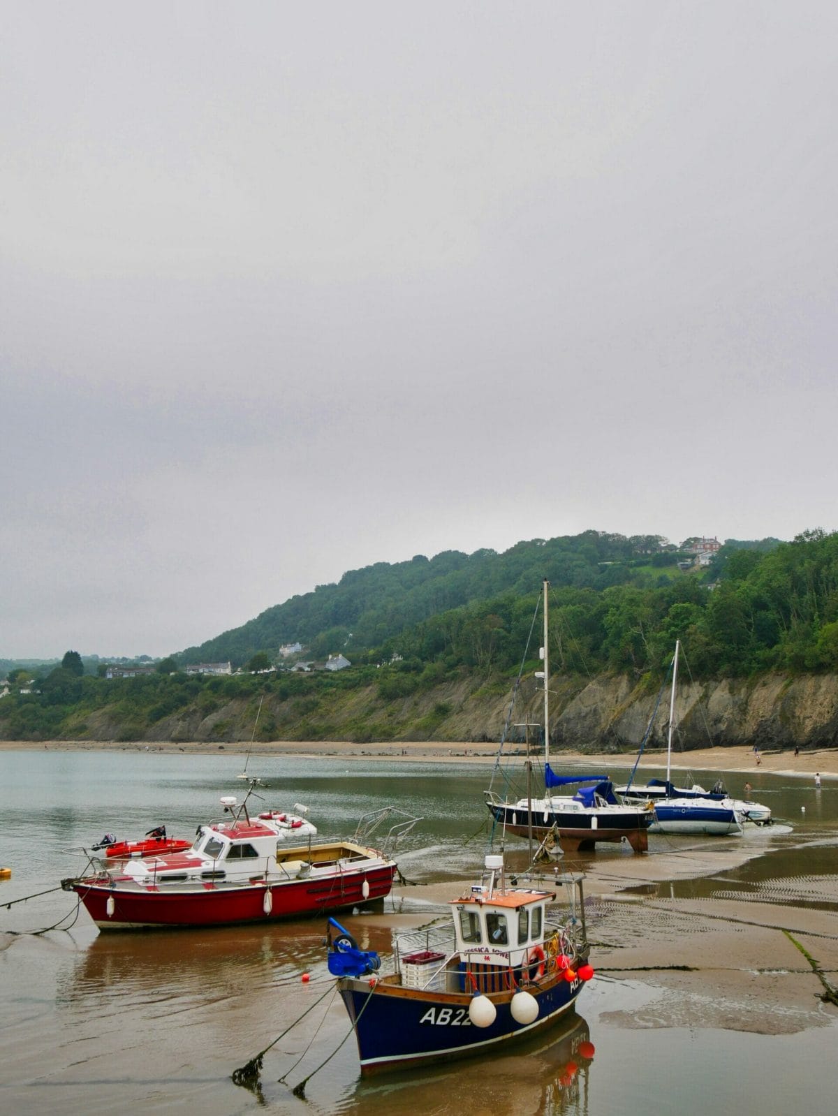 Some boats in the sandy water in New Quay in Wales