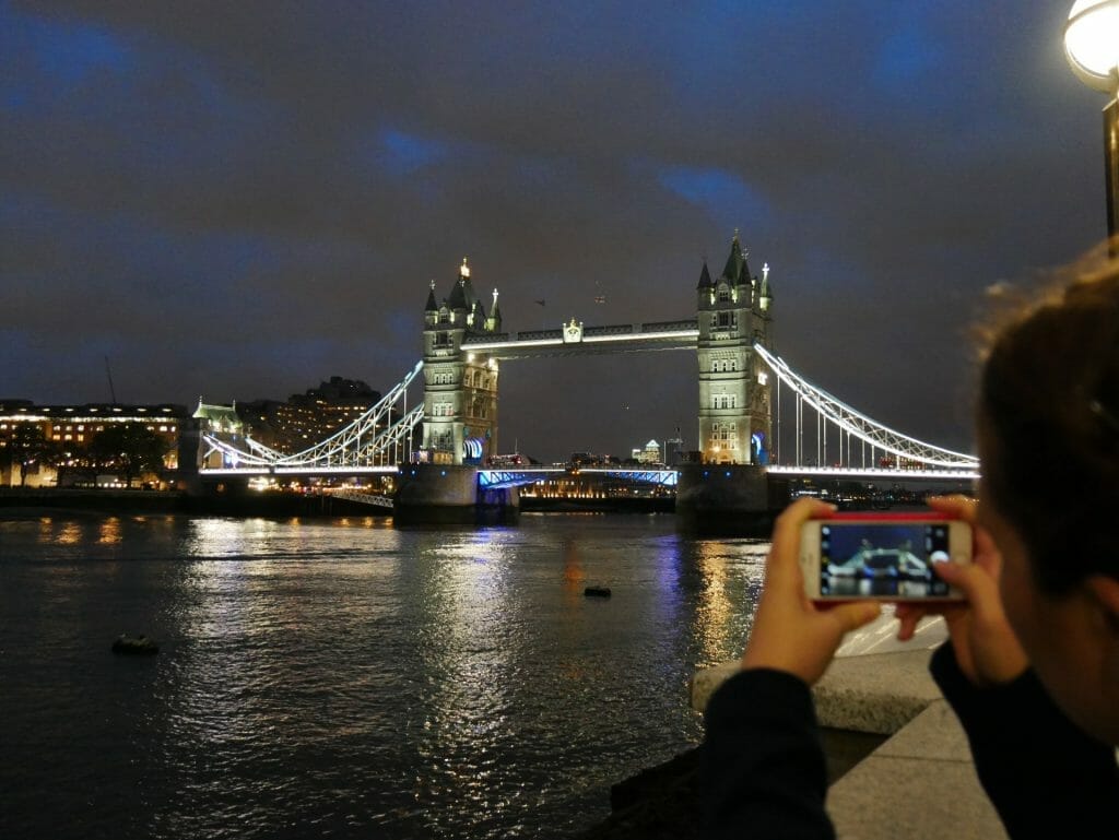 Kalyn taking a picture of Tower Bridge at night