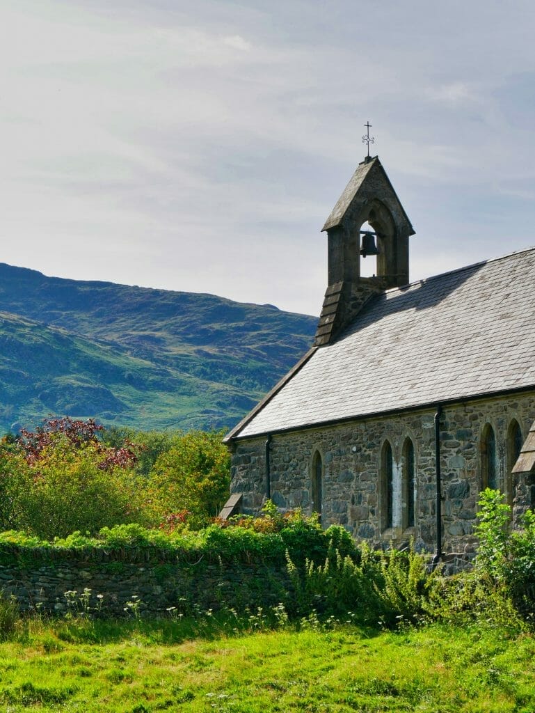 A church in Beddgelert, Wales, with a hill in the background