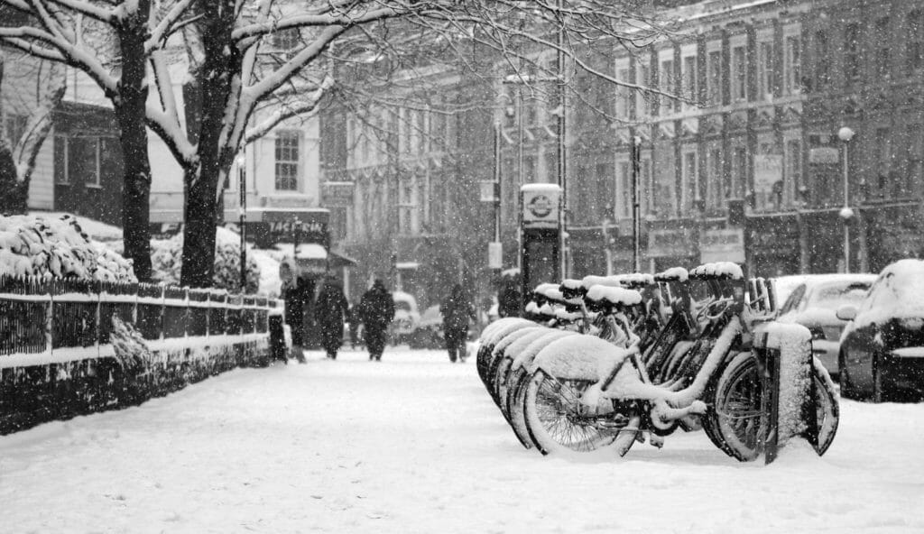 A row of bikes covered in snow in London