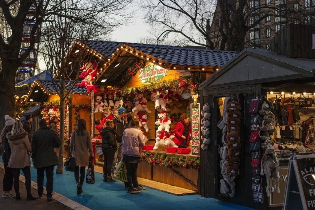 A Christmas Market with people standing outside a wooden store
