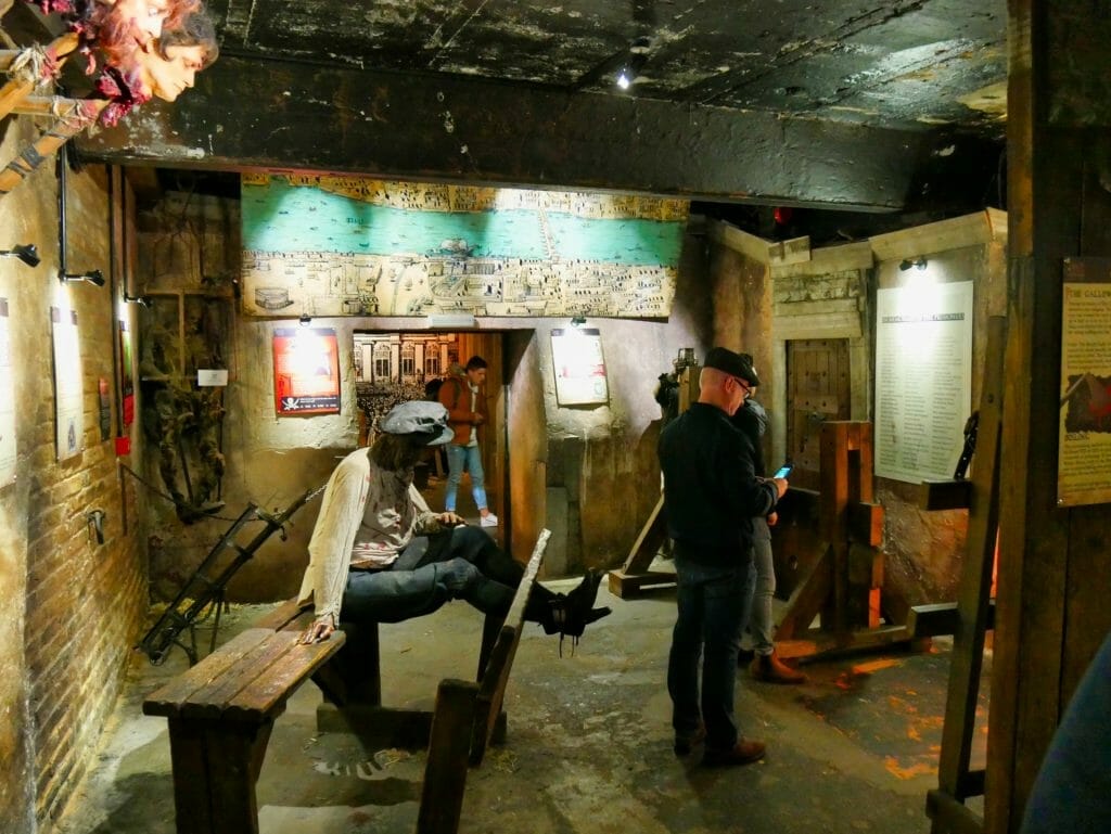 People looking at displays inside the Clink Prison Museum, London