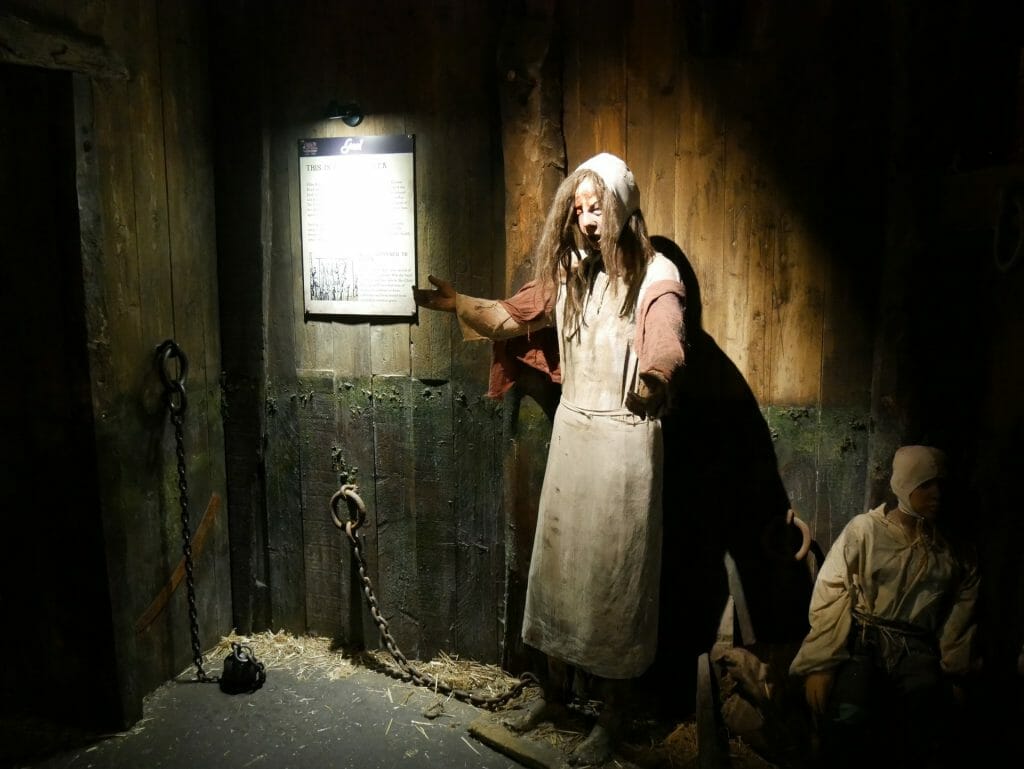 Model of woman standing next to information board at Clink Prison Museum, London