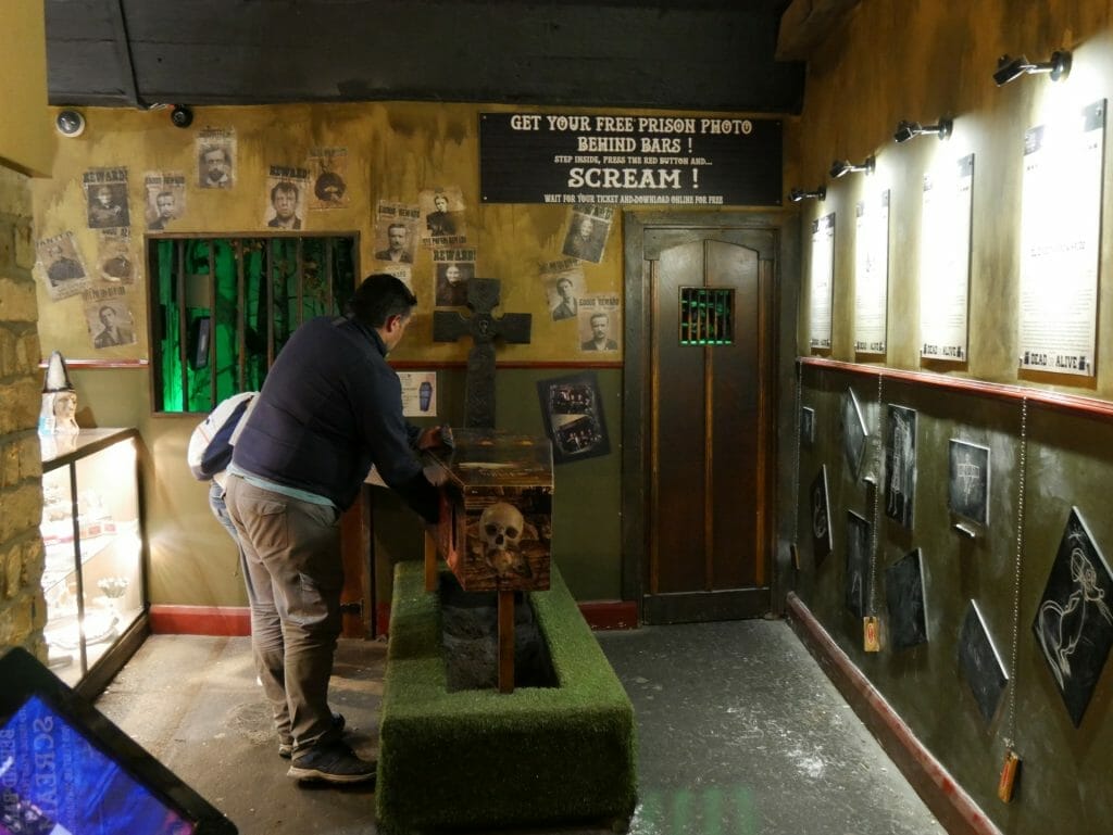 Man with hand in coffin at Clink Prison Museum, London