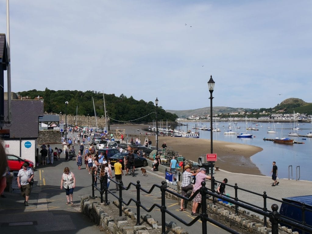 People looking out at boats in Conwy, North Wales
