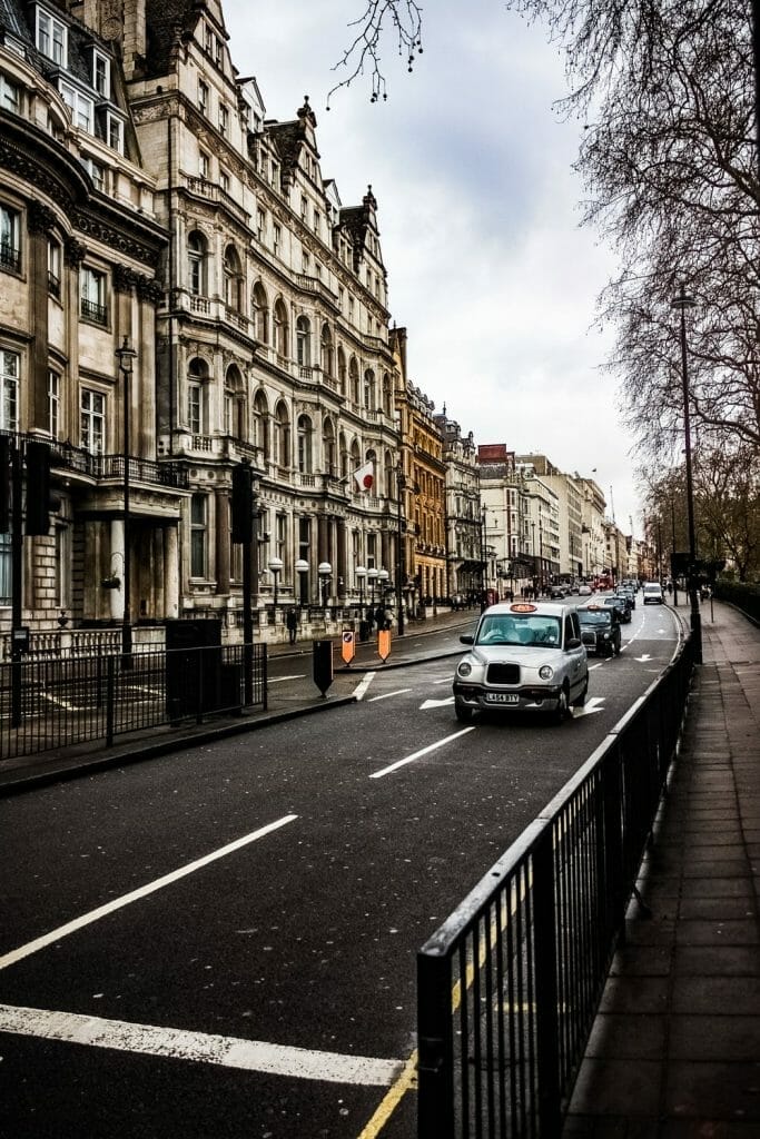 A London street with a row of taxis driving past