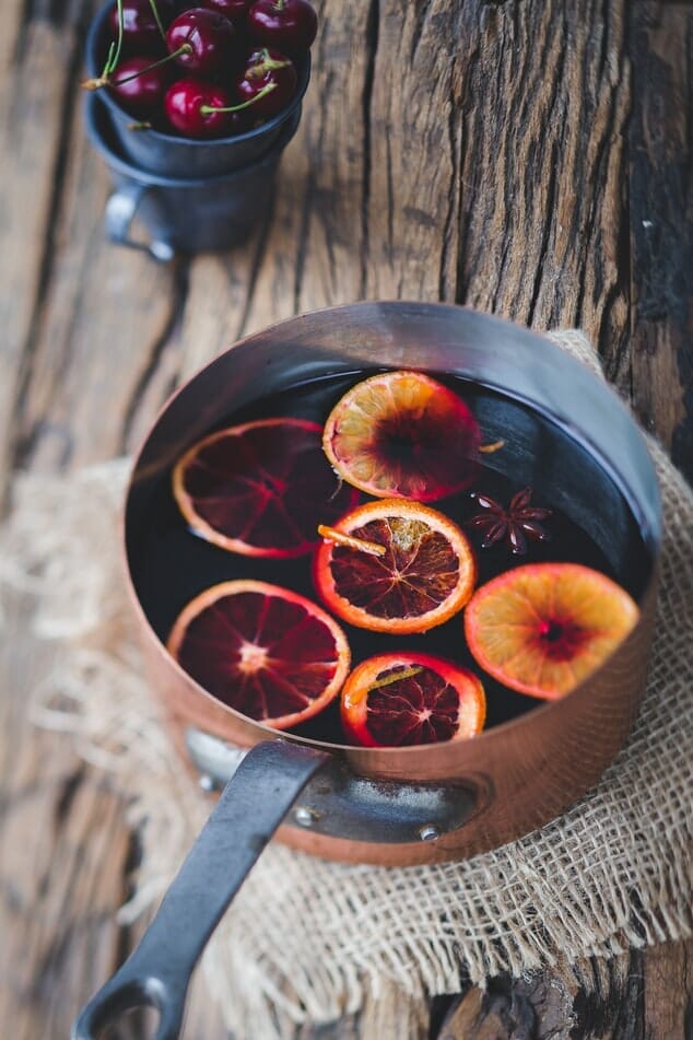 Mulled wine in a pot with fruit slices in it