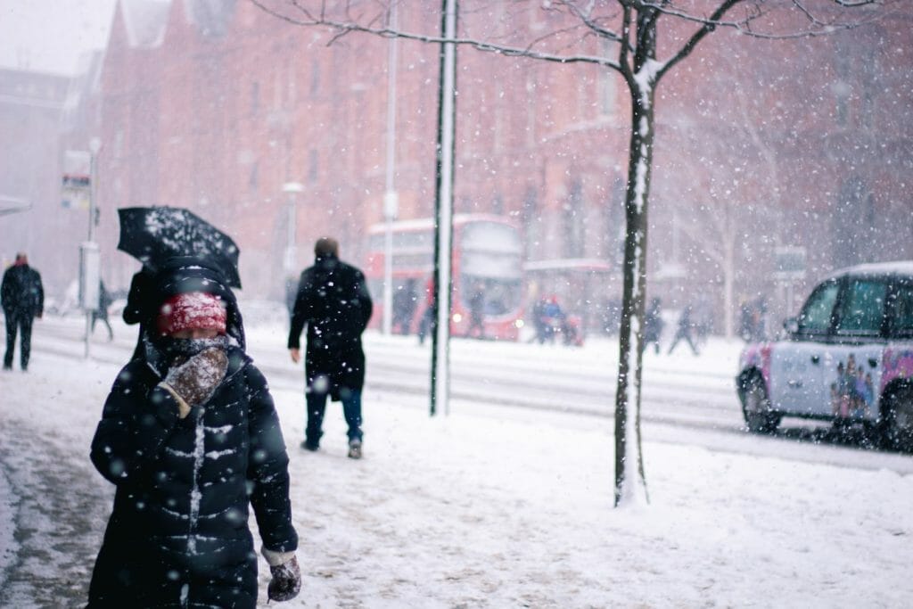 Person with face covered in snowy London and red bus in background