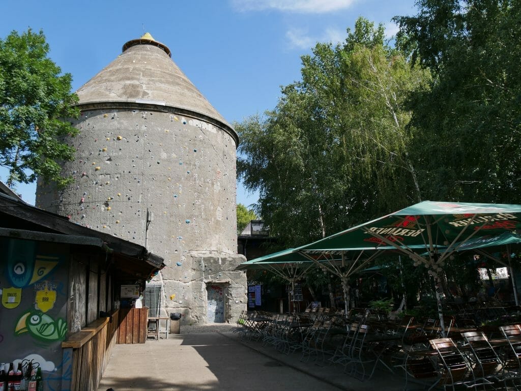 A stone silo with parasols in front of it in Berlin