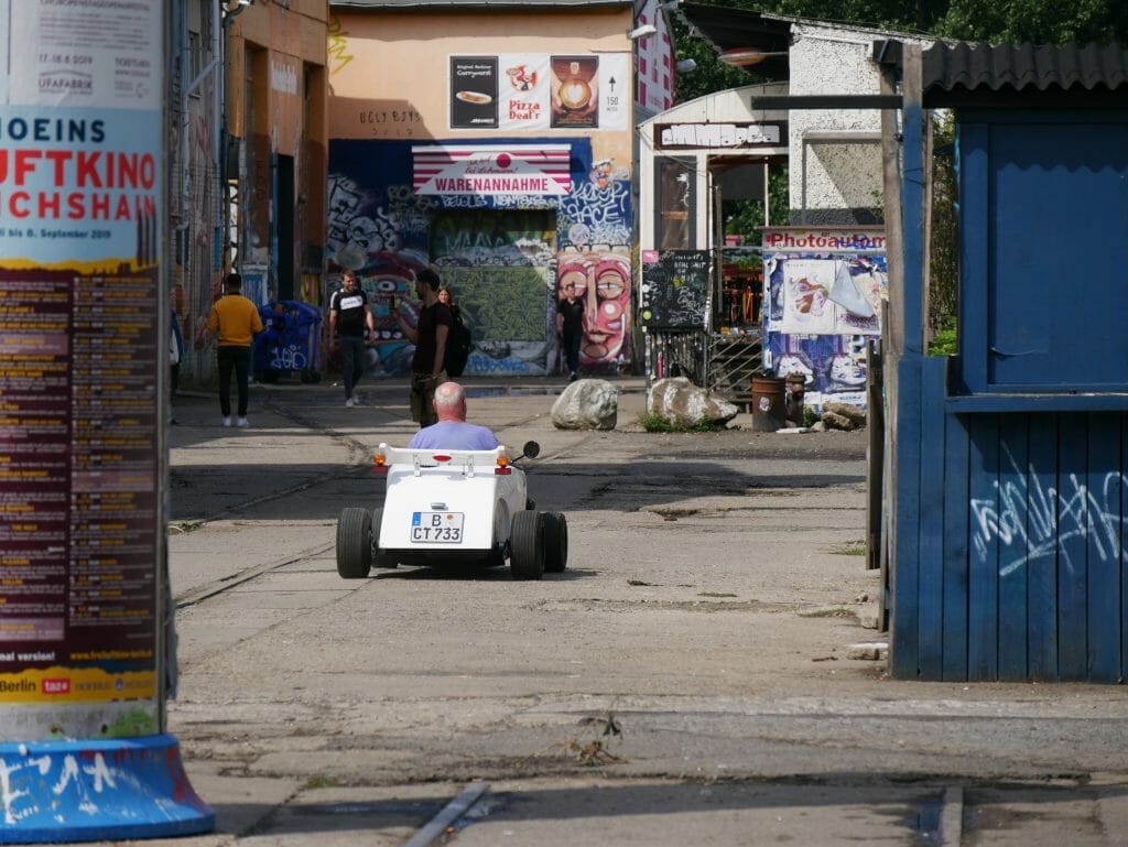 A man driving a small, motorized box car in Berlin