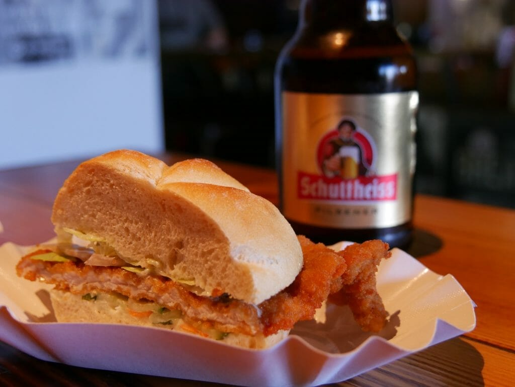 A Schnitzel with a bottle of beer behind it