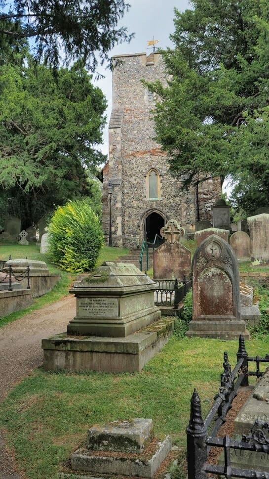 Front entrance of St Martin's Church in Canterbury with gravestones in front and a path