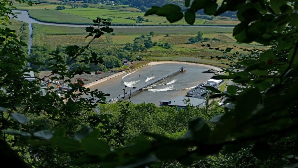 Man-made surfing lagoon seen from high above through gap in trees