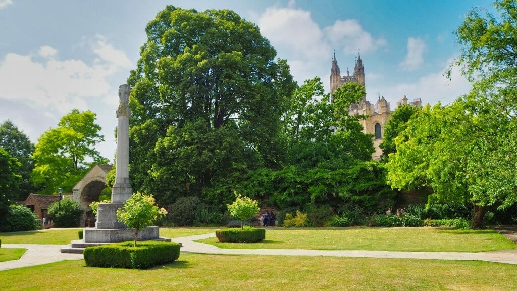 A green park with a view of Canterbury Cathedral in the background