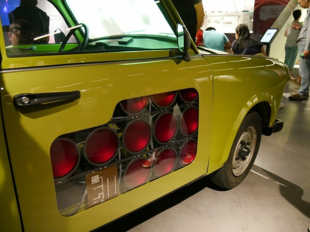 A mustard yellow Trabant car with infra-red lights built in to the passenger door at the German Spy Museum, Berlin