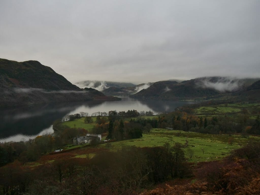 A view over Ullswater with cloudy skies and hills in the background